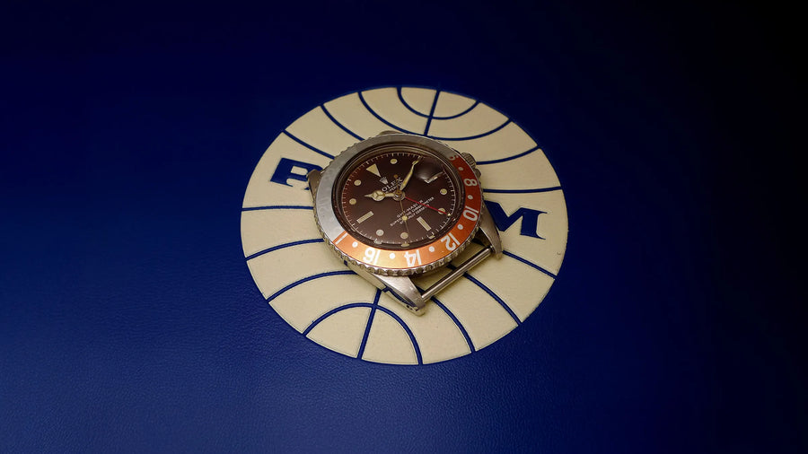 Rolex GMT-Master 6542 with faded bakelite bezel on Pan Am logo display stand